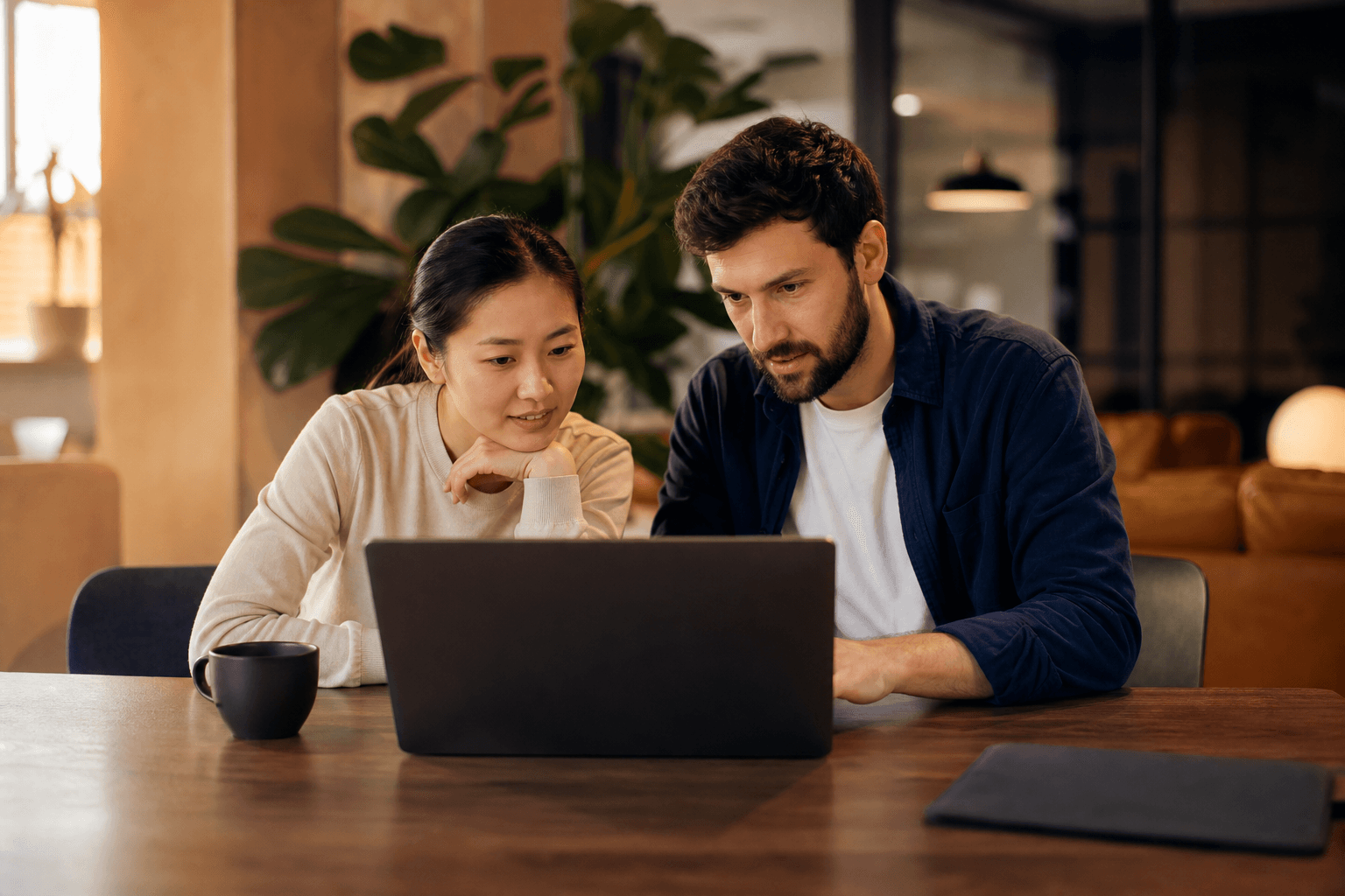 Person reviewing a generated web page on a laptop while checking notes on a second monitor